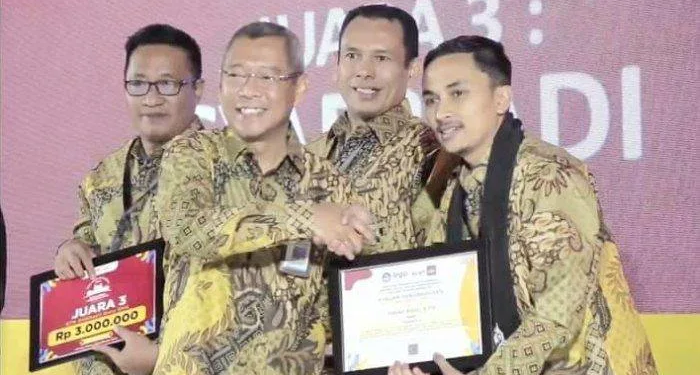 Kepala Balai Guru Penggerak (BGP) Provinsi Aceh, Dr Yudi Herman MPd menyerahkan hadiah kepada juara 1 Guru dan Tenaga Kependidikan (GTK) Dedikatif SMA, Hasan Basri dari SMAN 1 Mesidah, Kabupaten Bener Meriah