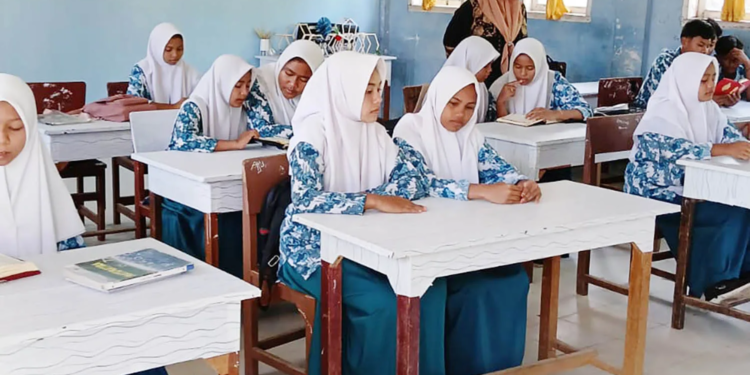 Siswa-siswi madrasah di Aceh Jaya rutin sedang mengaji sebelum belajar.