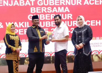 Gubernur Aceh, H. Muzakir Manaf, saat menerima buku karya Pj. Gubernur Aceh Periode 2024-2025, Dr. H. Safrizal ZA, M.Si, pada acara Malam Pisah Sambut, di Anjong Mon Mata, Banda Aceh, Rabu, (12/2/2025).