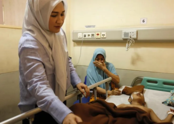 Ketua TP-PKK Aceh, Ny. Marlina Muzakir, saat menjenguk Jelita Sinaro, pasien anak penderita tumor ganas asal Desa Padang Hilir, Kecamatan Susoh, Abdya yang sedang dirawat di Rumah Sakit Umum Daerah Zainoel Abidin (RSUDZA) Banda Aceh, Minggu, (23/3/2025).