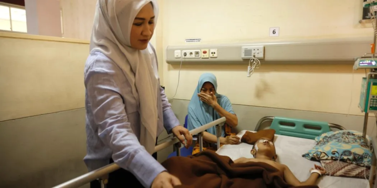 Ketua TP-PKK Aceh, Ny. Marlina Muzakir, saat menjenguk Jelita Sinaro, pasien anak penderita tumor ganas asal Desa Padang Hilir, Kecamatan Susoh, Abdya yang sedang dirawat di Rumah Sakit Umum Daerah Zainoel Abidin (RSUDZA) Banda Aceh, Minggu, (23/3/2025).