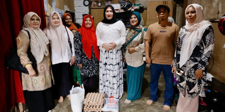 Ketua TP-PKK Aceh, Ny. Marlina Muzakir, didampingi Anggota DPRK Aceh Utara Yulianti, foto bersama saat meninjau langsung rumah warga kurang mampu pada sejumlah gampong yang berada di Kota Lhokseumawe, Kamis (20/3/2025)
